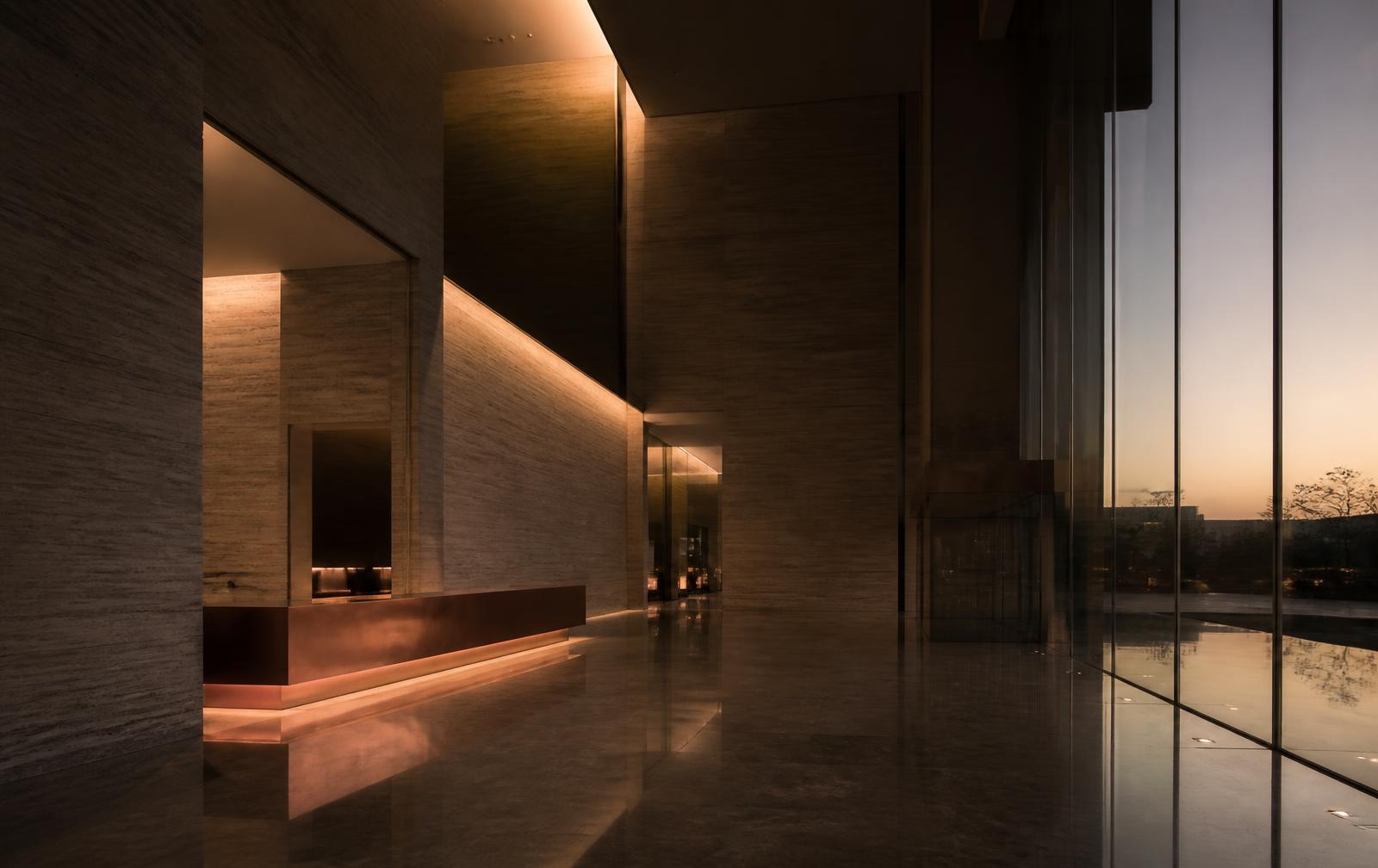 Monumental travertine corporate atrium at dusk
